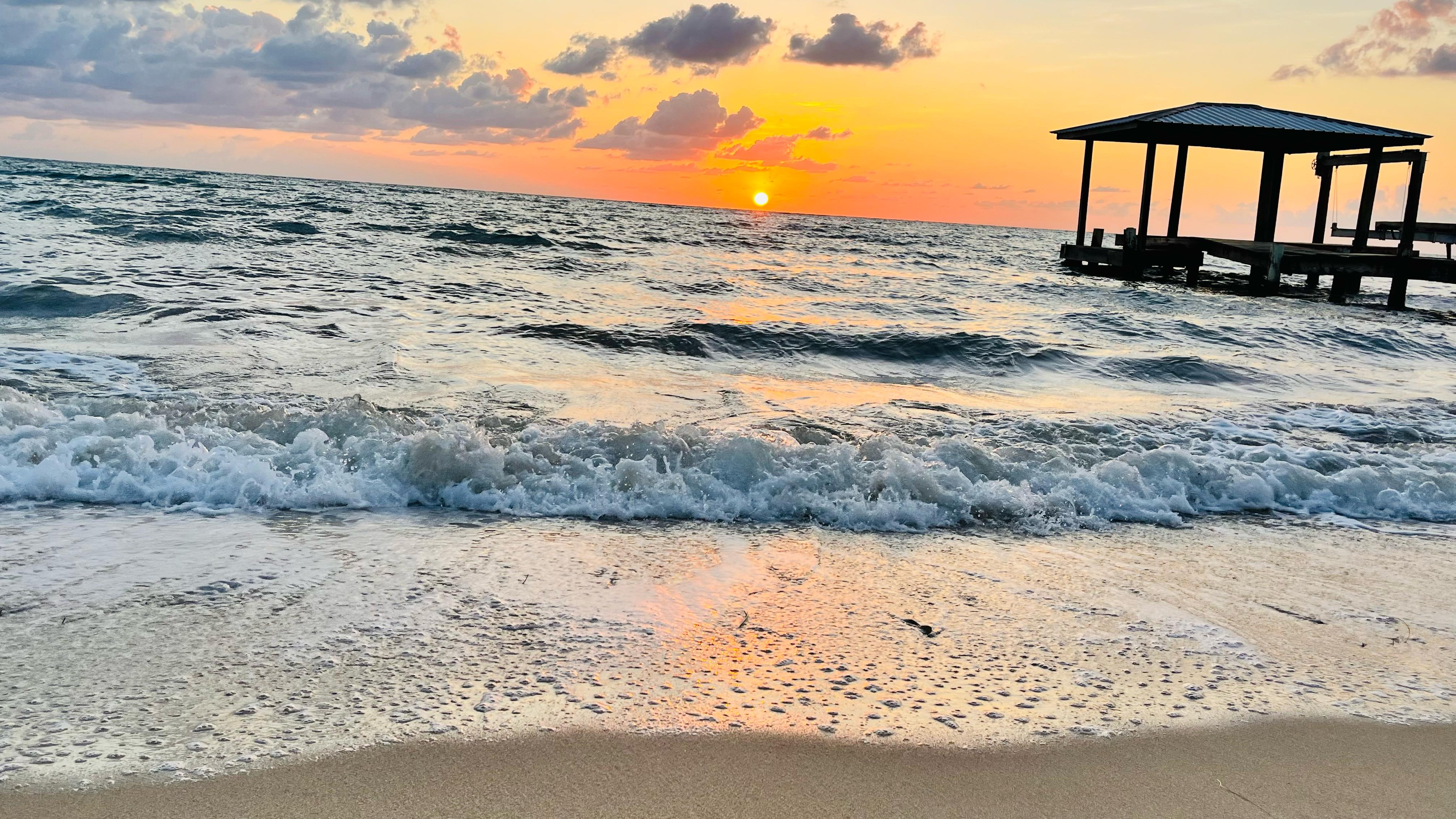 Sunset and pier on Maya Beach at Coral Cove Inn